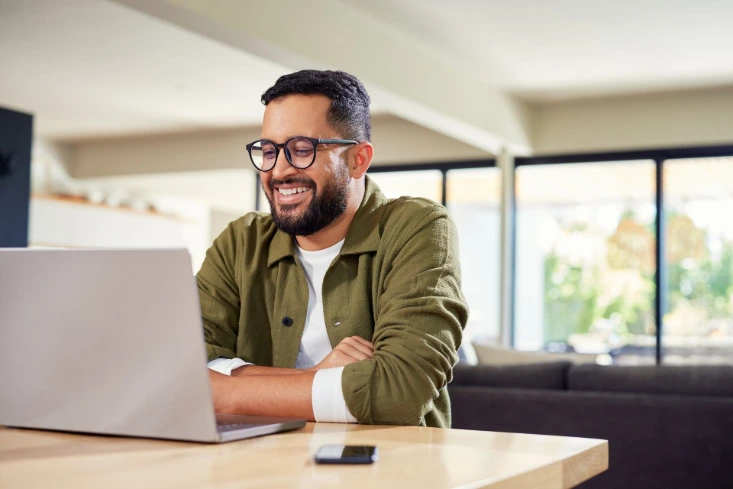 Man smiling at a computer