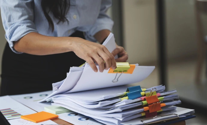 Woman flipping through paper collections
